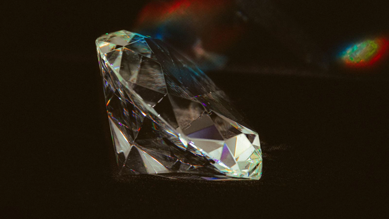 Diamond with prismatic light reflections on a dark background