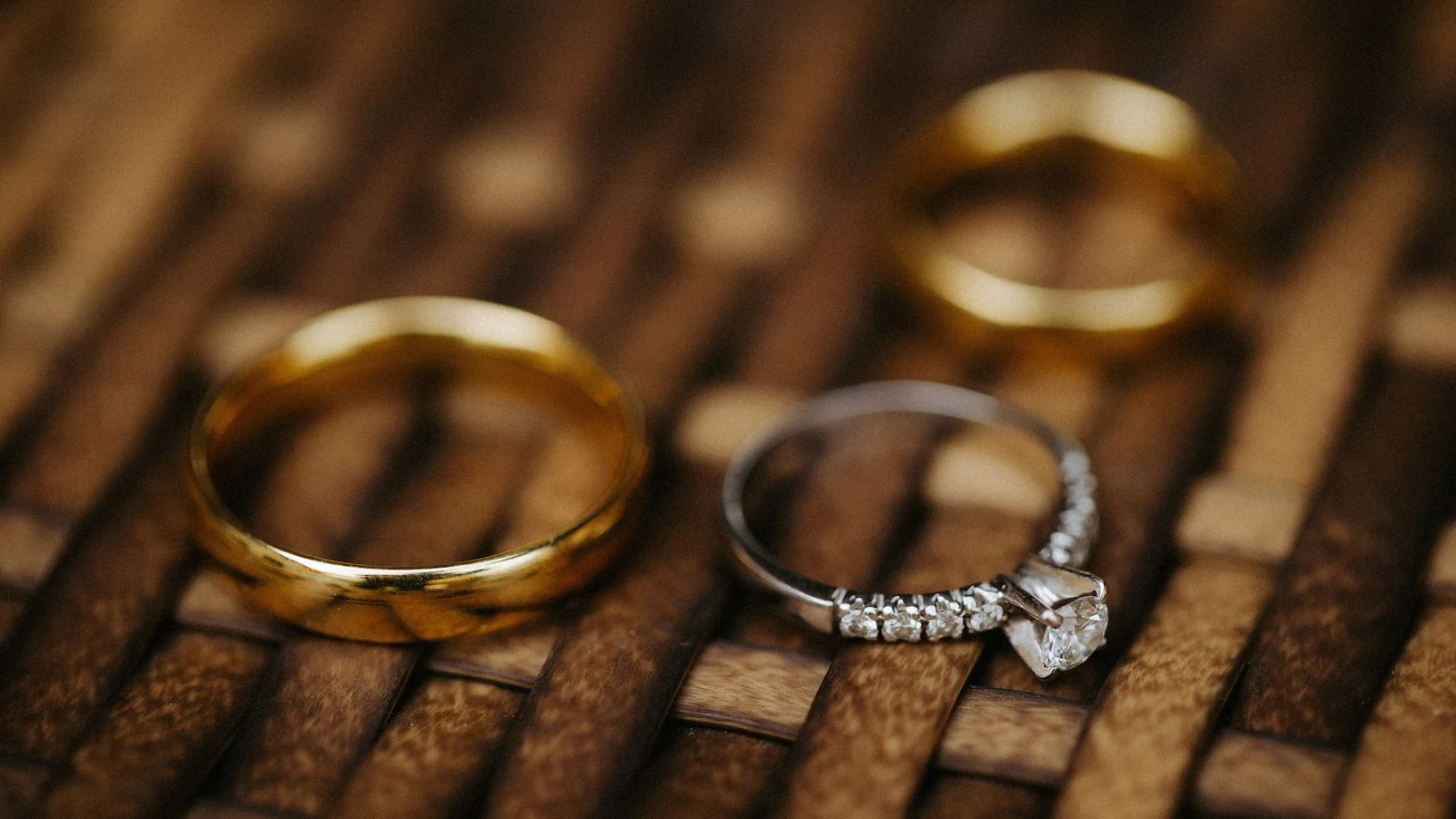 Gold wedding bands beside a diamond engagement ring