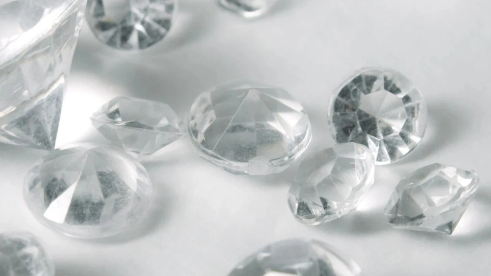 Several clear-cut diamonds side by side on a white surface