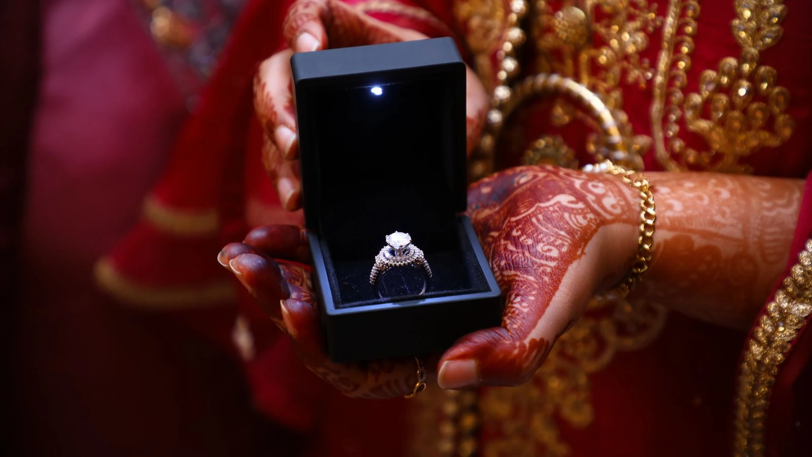 Diamond ring in a presentation box held in a pair of hands