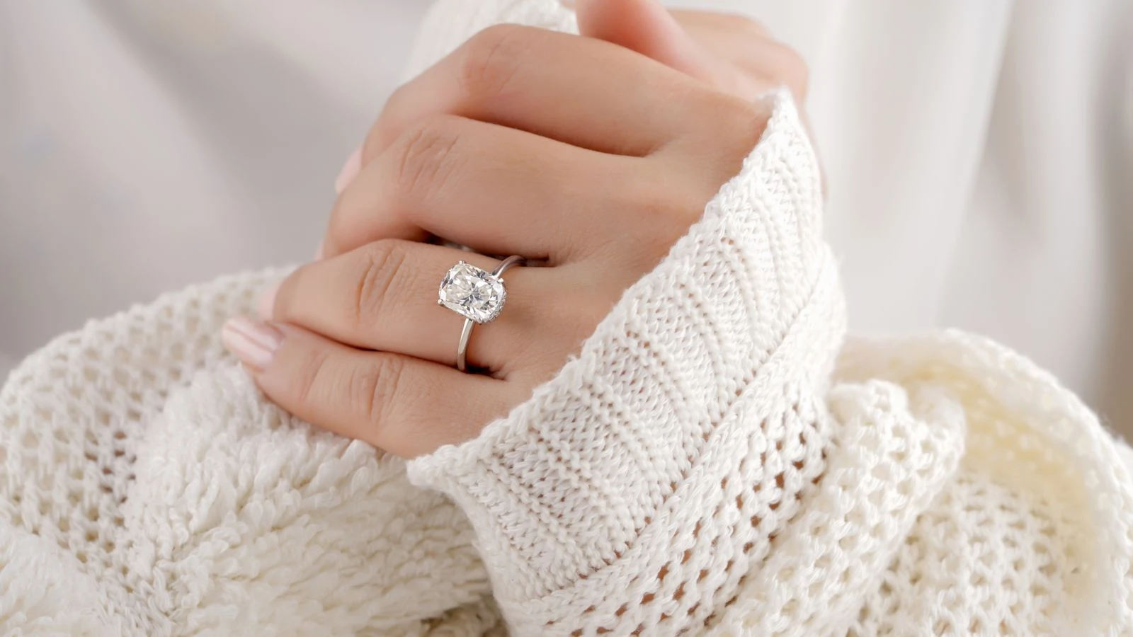 Diamond engagement ring worn on a hand, showing its elongated silhouette