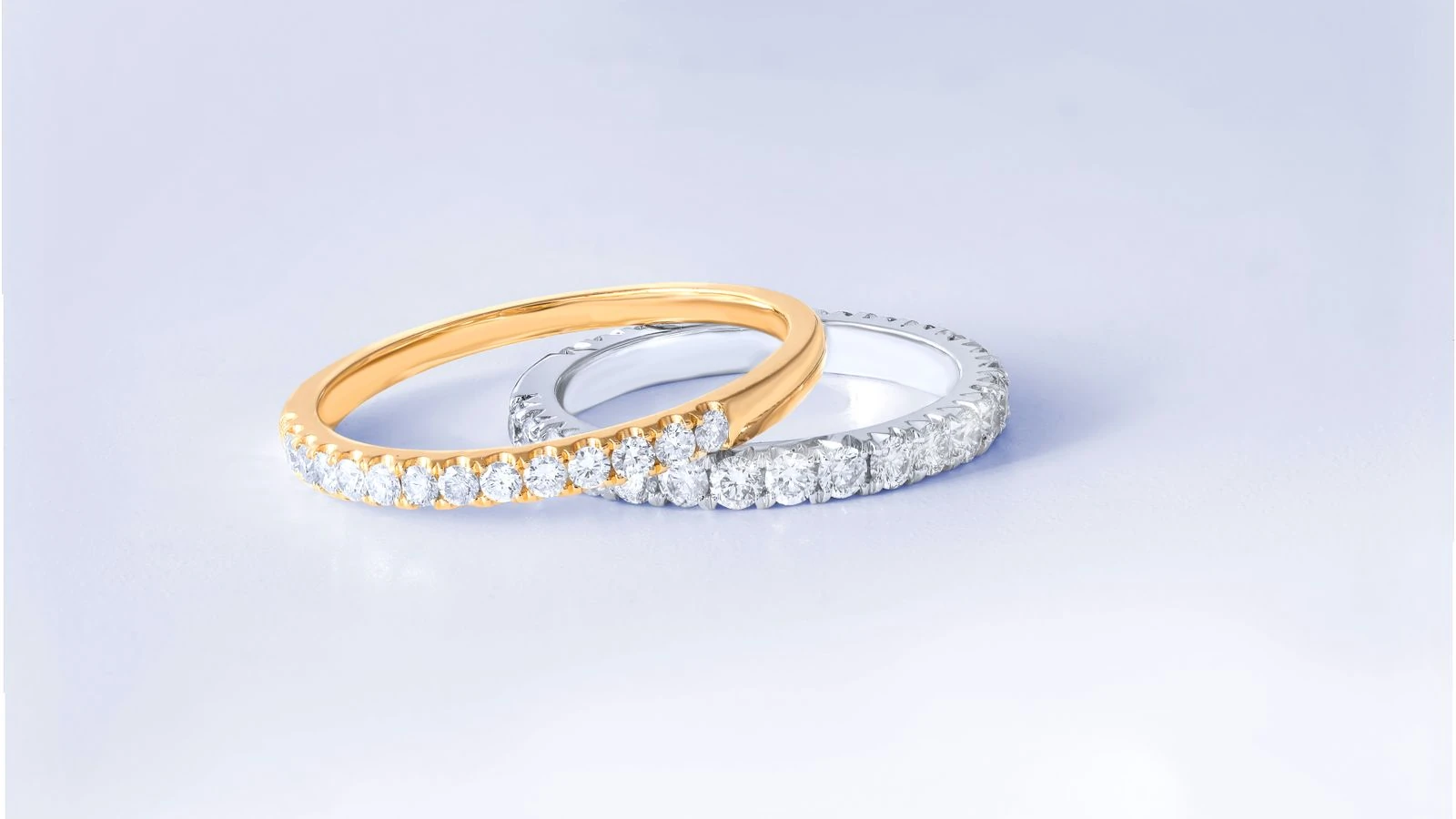 Two diamond rings in gold and silver settings shown side by side